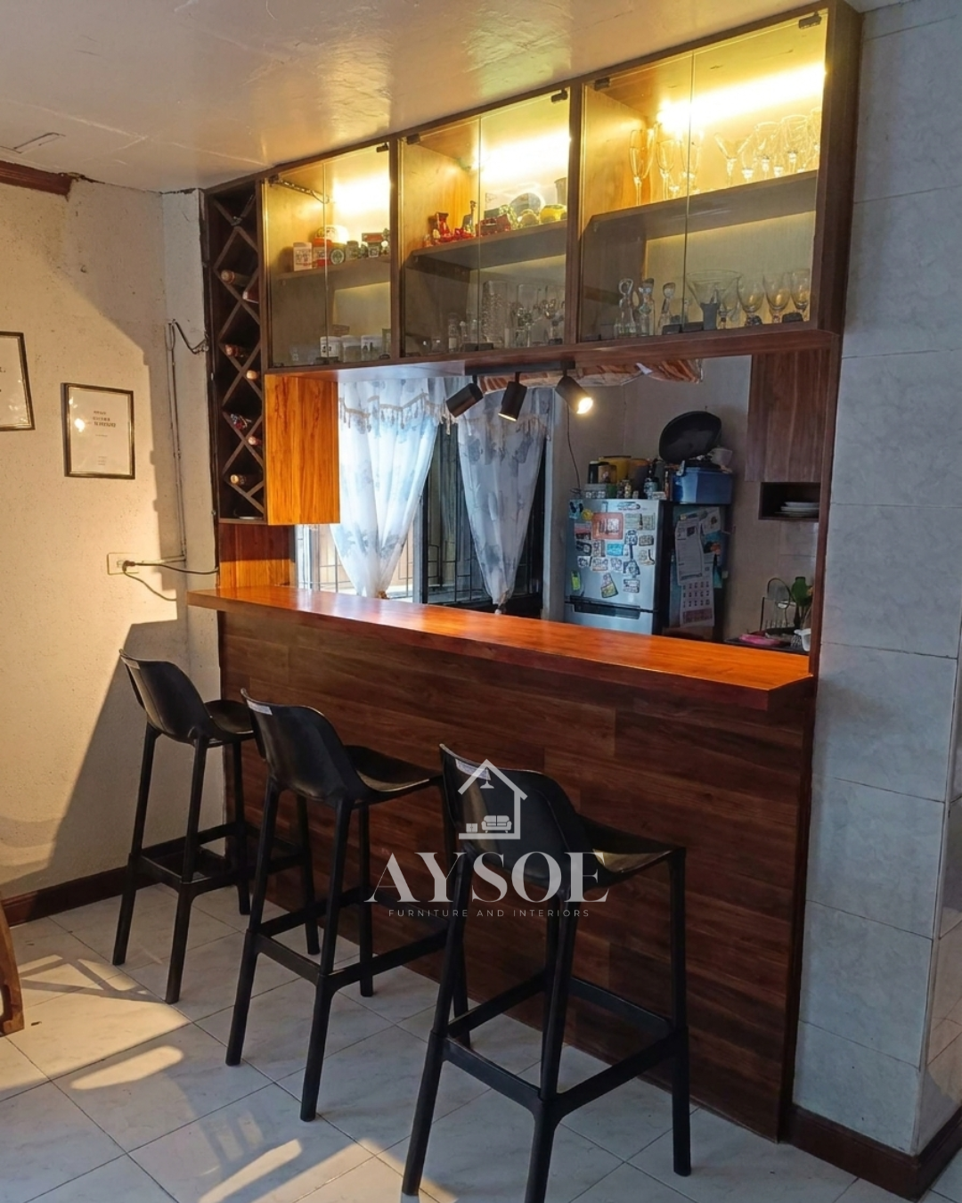 A custom home bar counter with a walnut wood-grain front, a glossy bar top, lighted glass display cabinets, and a diamond wine rack. Turns a kitchen opening into a stylish bar.