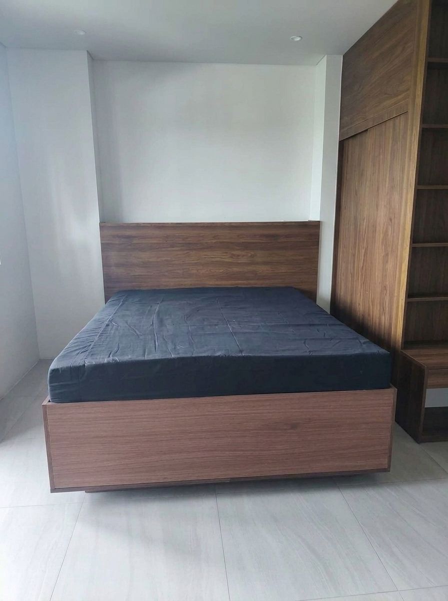 A modern walnut wood-grain platform bed that looks like it’s floating, with warm LED lighting underneath and a full-width panel headboard. Clean lines, rich grain, and a calm, hotel-style glow.