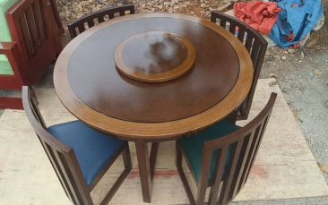 Chairs: Four matching wooden slat-back chairs with sturdy frames and cushioned seats. The cushions shown include blue and green upholstery.