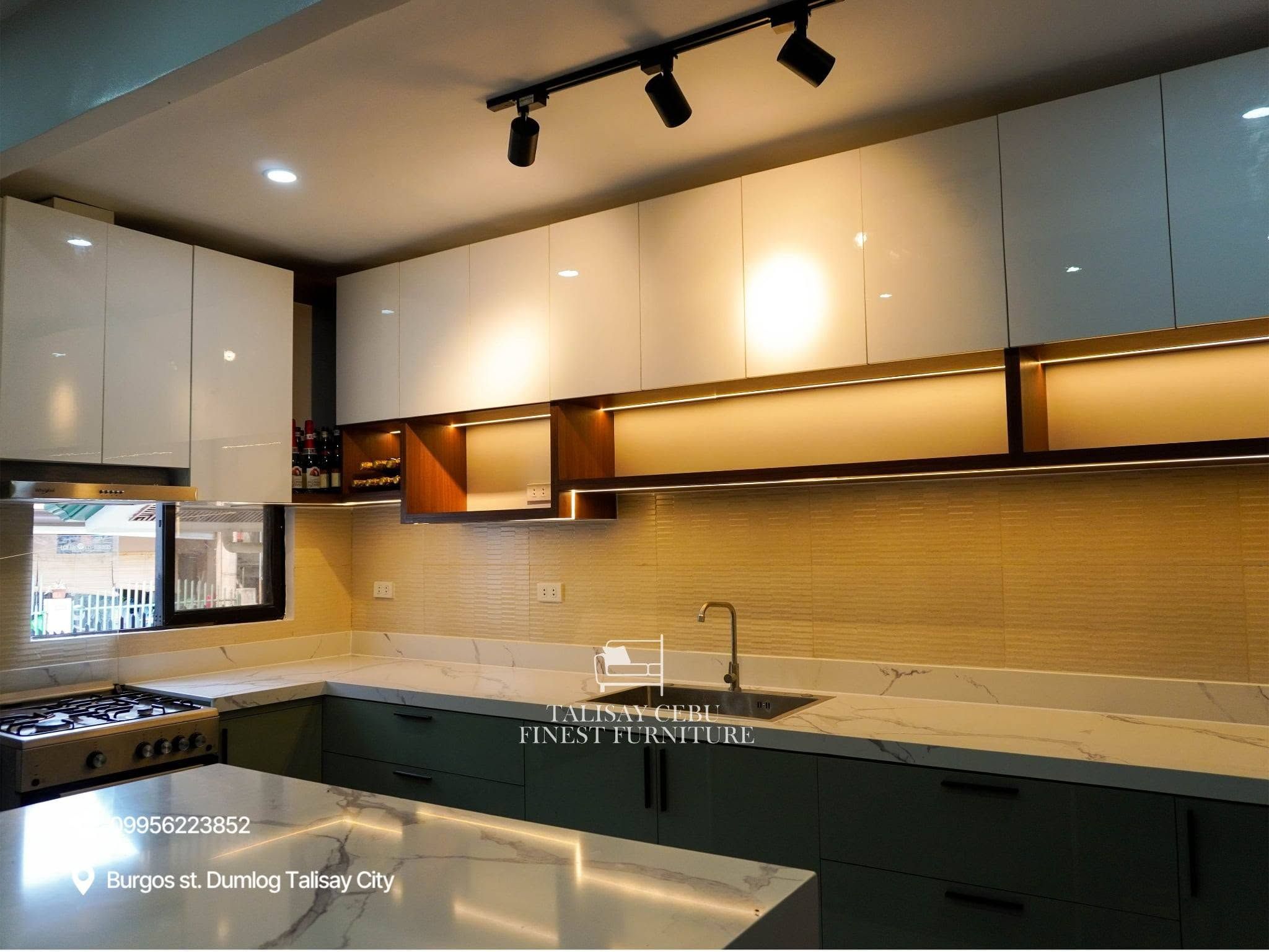 Kitchen Island positioned in the foreground, the island features a thick white marble-look countertop with distinct grey veining. 