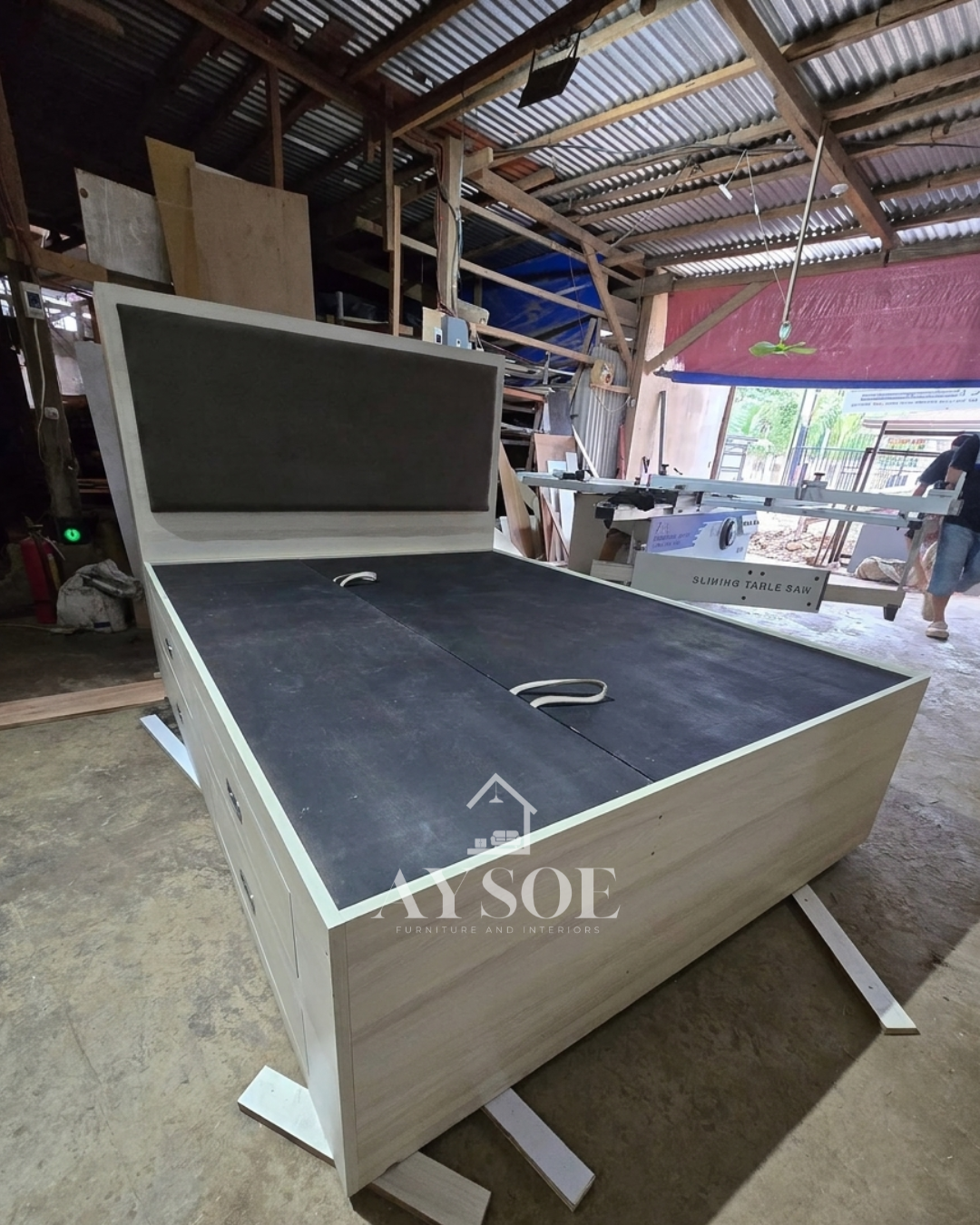 A light oak storage bed with a lift-up platform, four side drawers, and a padded grey headboard. Huge hidden storage for bedding, clothes, and extras.