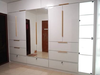 Custom built-in wardrobe with mirrored doors, spacious storage, and sleek modern cabinetry.