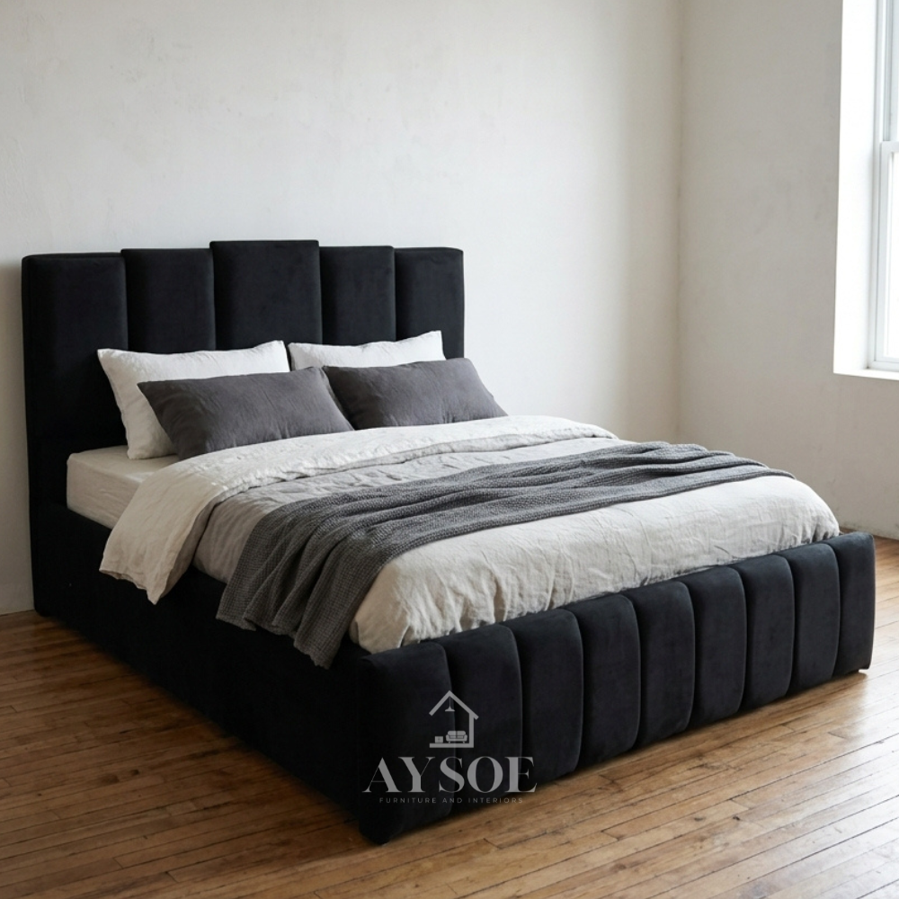 Black velvet-style bed with a tall headboard of five staggered vertical panels, a channel-paneled footboard, and a wrapped frame. Available in various sizes, with optional storage.
