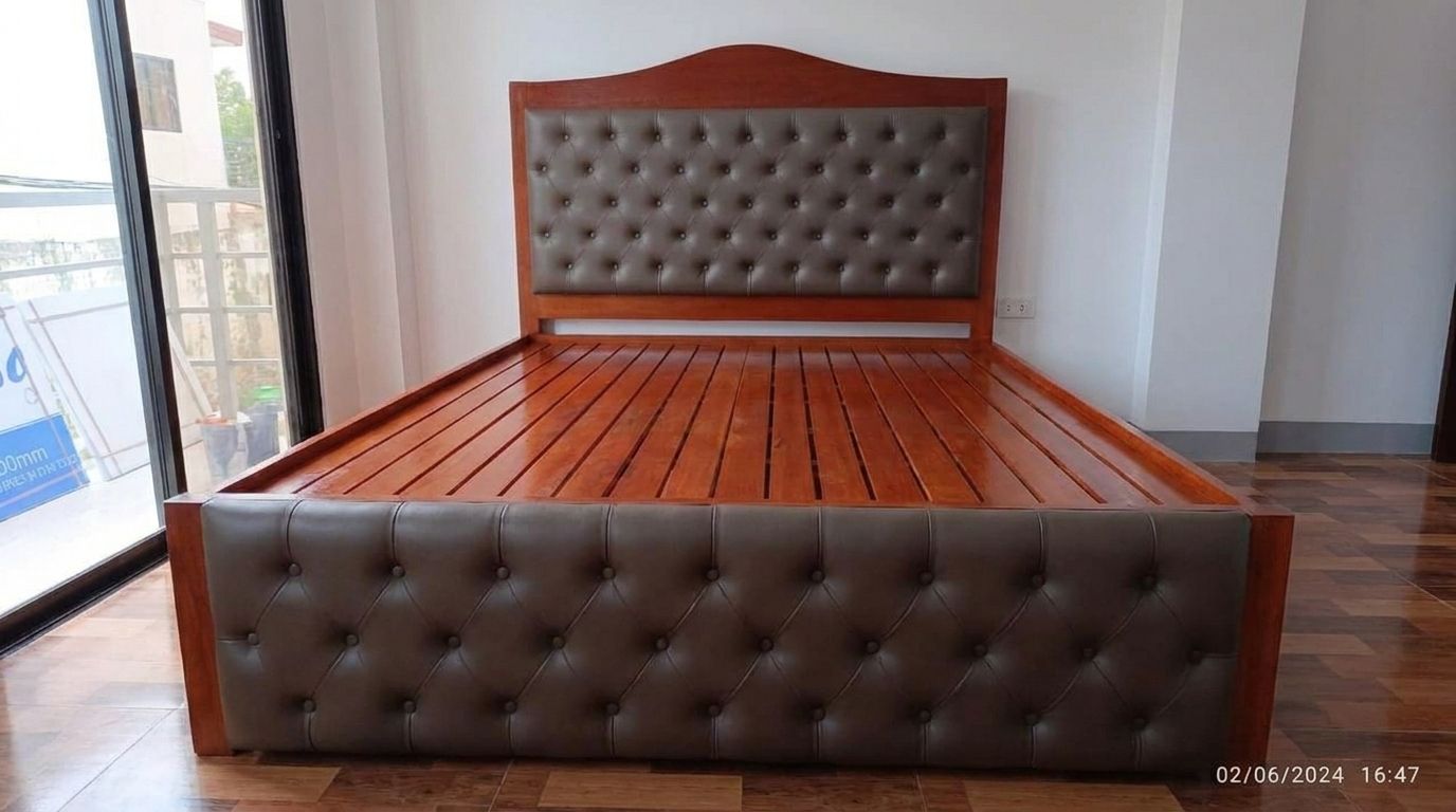 A solid wood bed in a rich glossy cherry finish, with an arched headboard, taupe button-tufted leatherette panels on the headboard and footboard, a slatted base, and built-in side drawers.