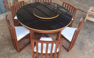 Six matching mahogany wooden chairs with vertical slat-back designs and white cushioned seats.