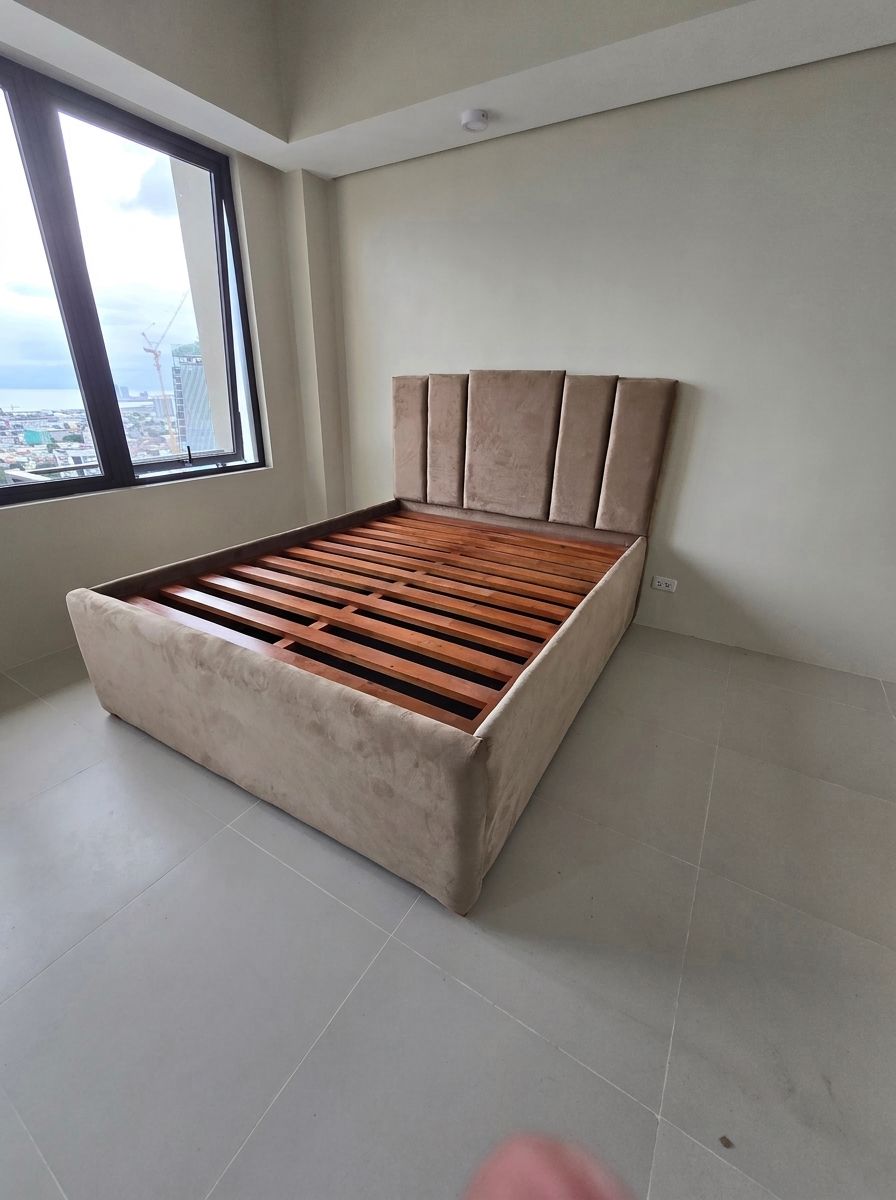 A modern upholstered bed in soft taupe suede-style fabric, with a vertical channel headboard and a gas-lift base that opens to a huge hidden storage space. Clean, calm, and built to save space in condos and bedrooms.