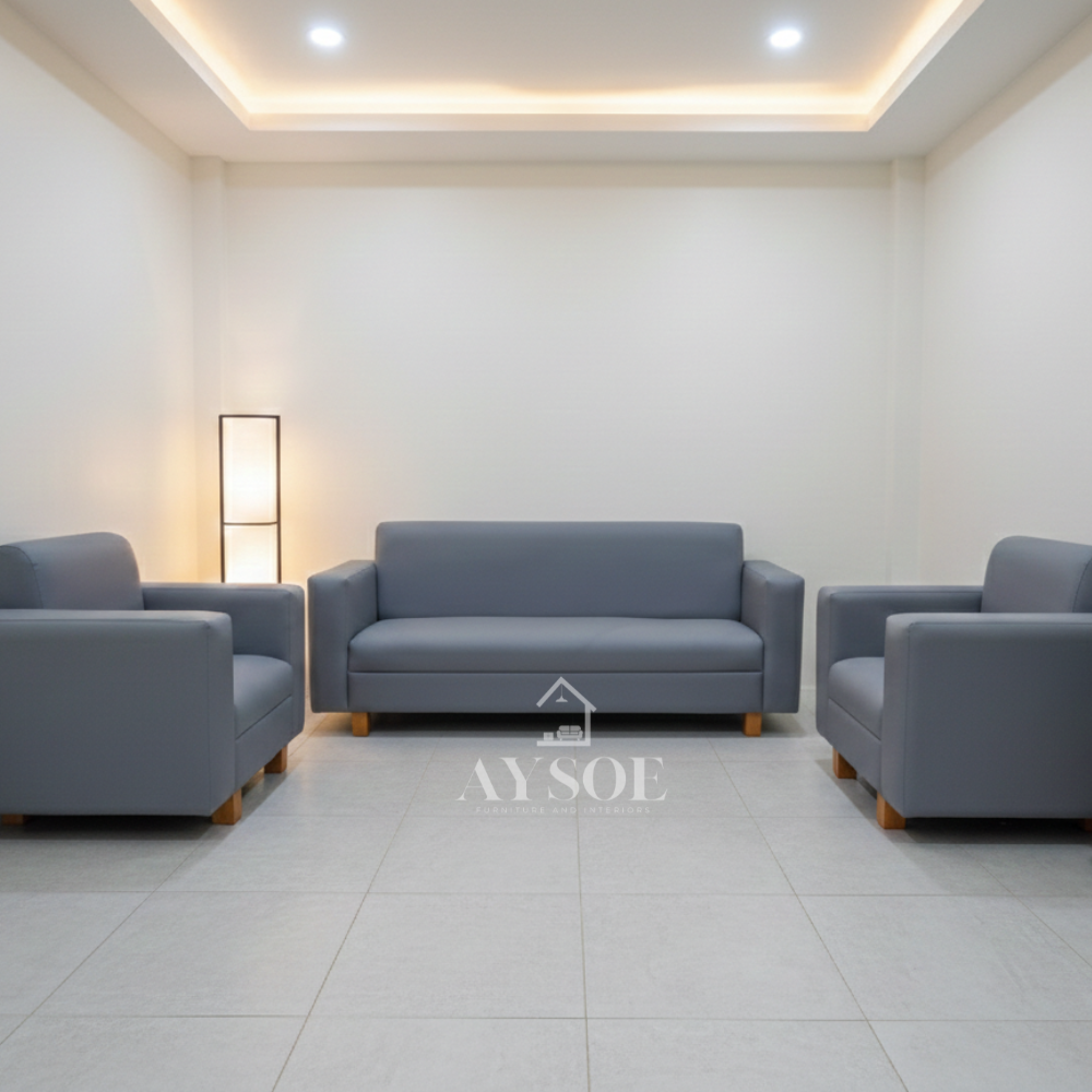 A modern 3-piece living set in slate gray leatherette, with a three-seater sofa, a loveseat, and an armchair. Clean boxy lines, wipe-clean upholstery, and warm wood block legs.