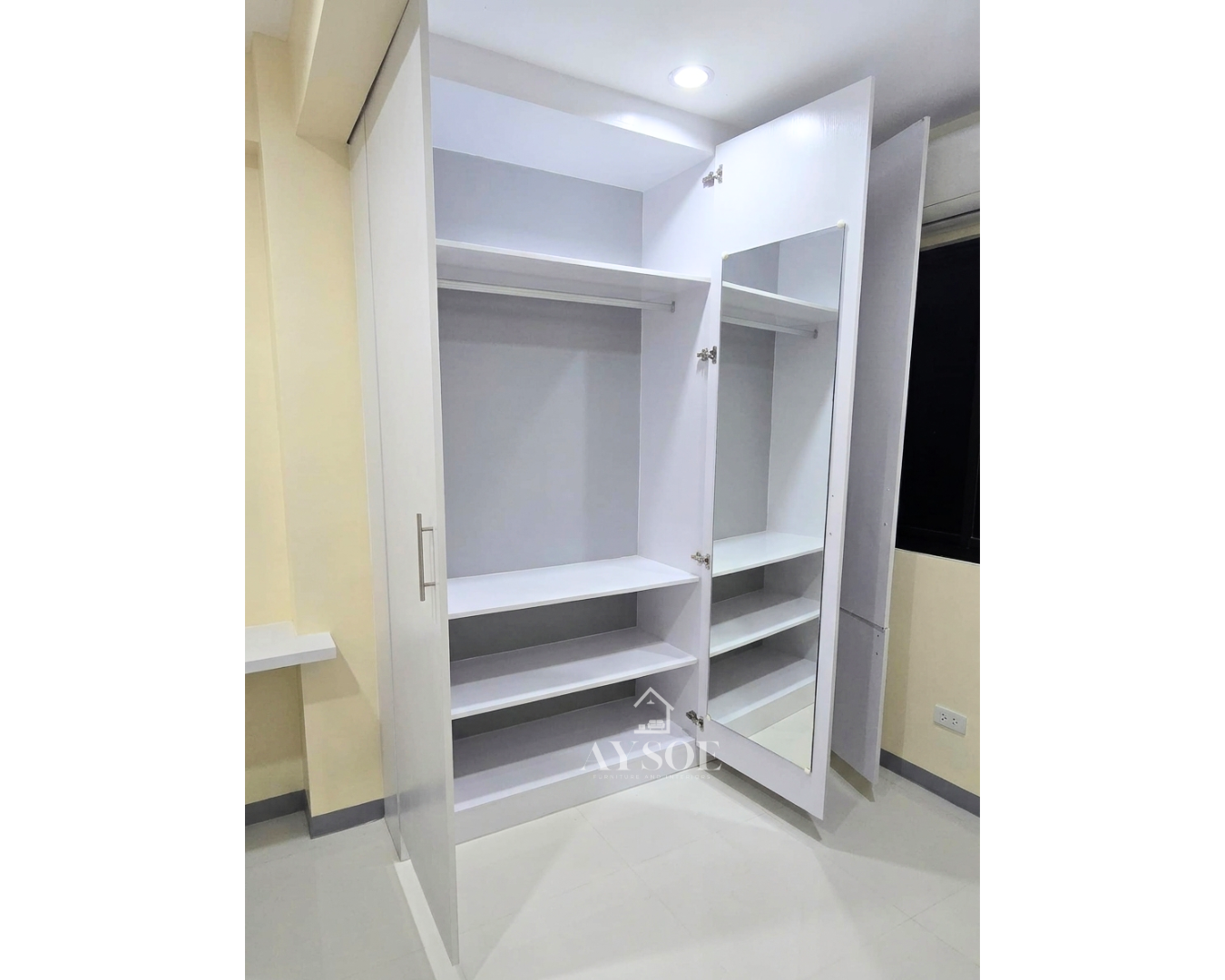 A custom white built-in wardrobe with hanging rods, open shelves, and a full-length mirror door. Roomy, organized storage for any bedroom.