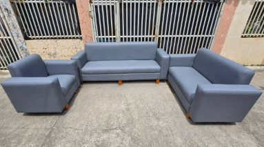 The Seating Arrangement: A long 3-seater sofa anchors the back wall, flanked symmetrically by two large, deep matching single-seater armchairs facing inward.