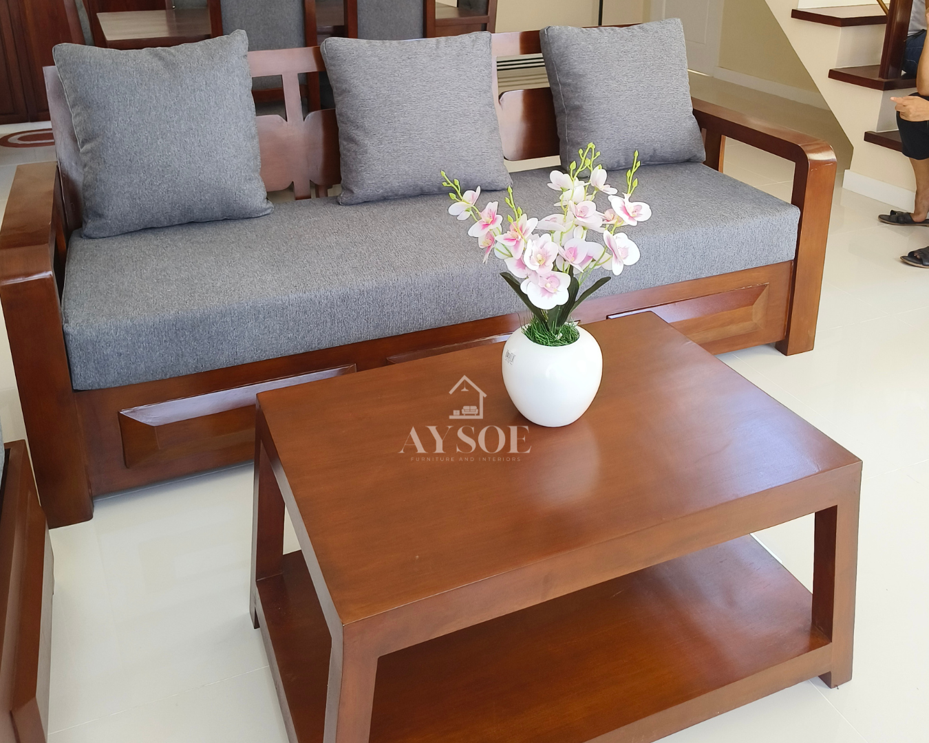 Cherry-finish solid wood living set: 3-seater sofa, matching chaise bench, and coffee table, with thick gray cushions and large lumbar pillows. Comfortable and easy to style.