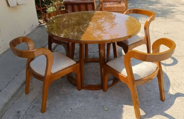 Four matching solid-wood chairs with beautifully curved armrests and backs. Each chair has a light-colored cushioned seat for added comfort.