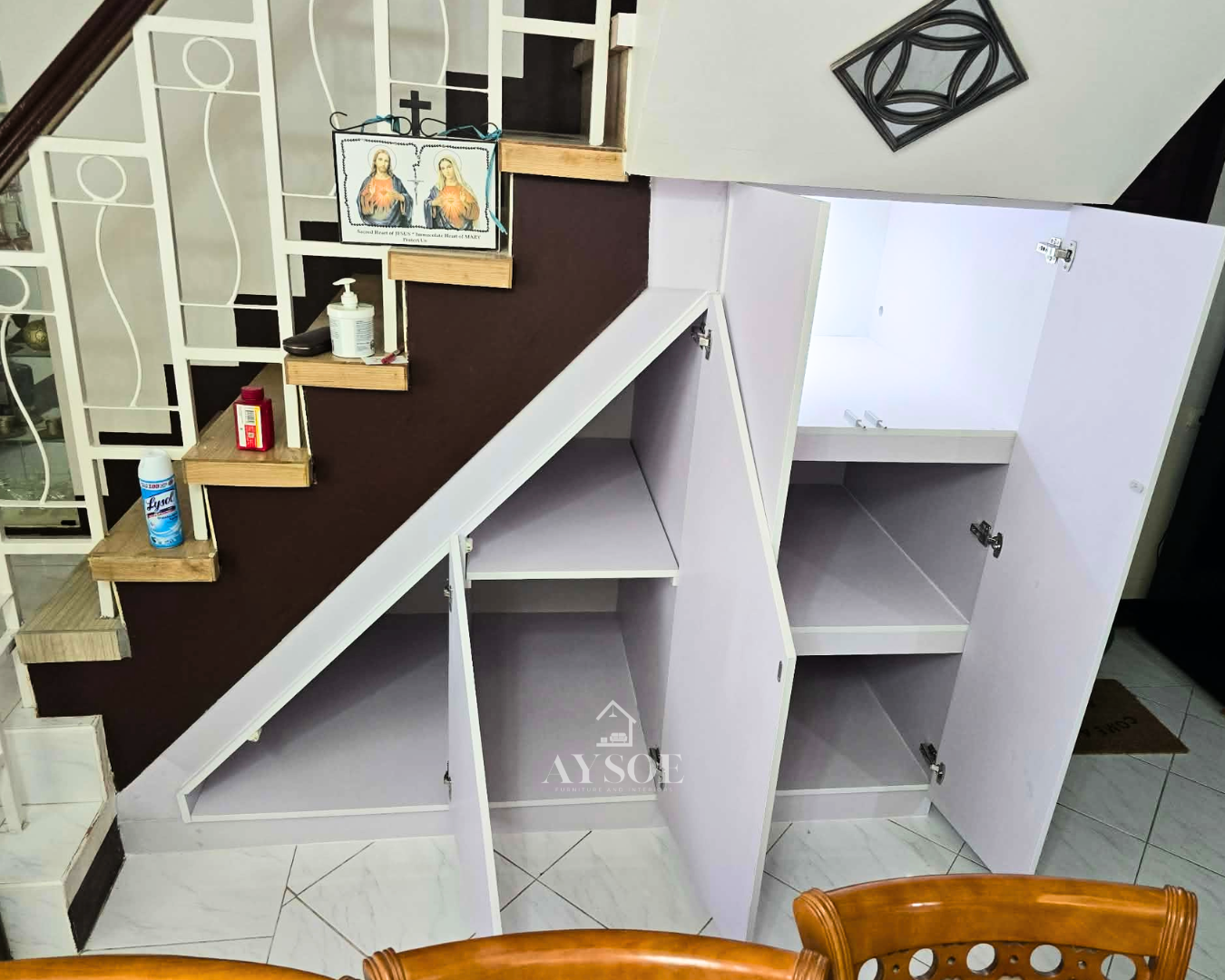 A custom under-stair storage cabinet in a clean white finish, with hinged doors, roomy shelves, and a tall cabinet section. Turns unused stair space into organized storage.