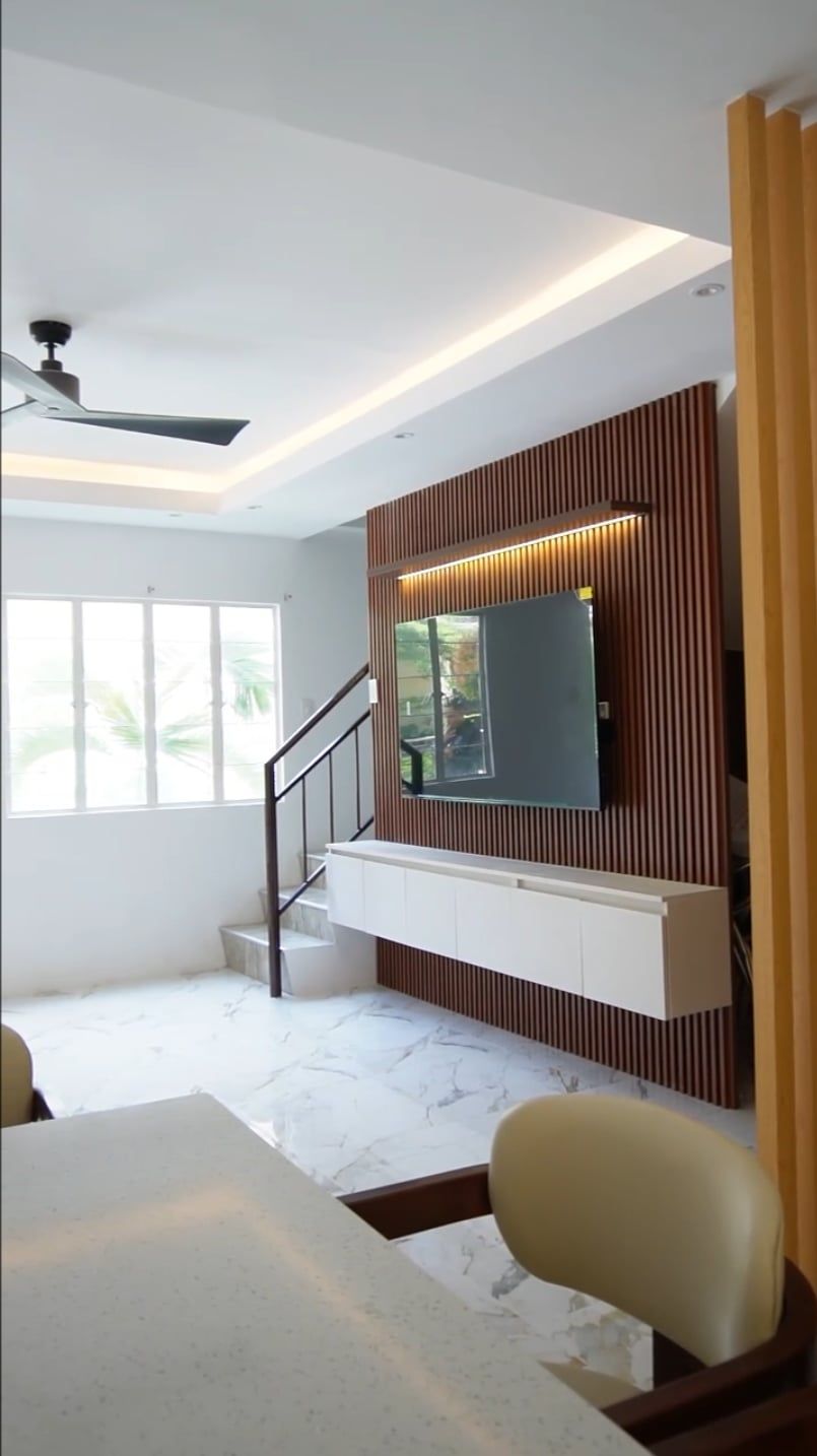 Floating white TV console with a warm slatted wood feature wall and matching accent panel.