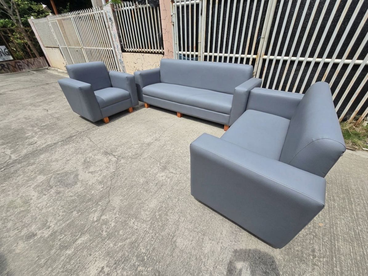 The Seating Arrangement: A long 3-seater sofa anchors the back wall, flanked symmetrically by two large, deep matching single-seater armchairs facing inward.