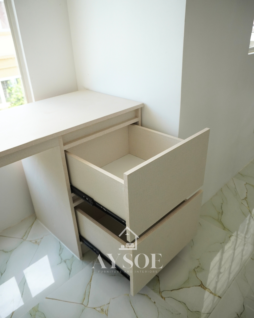 A custom bedroom set in a cream linen-texture finish, with a built-in study desk with two drawers and two wardrobes with hanging rods and shelves. Complete storage and a work spot for small rooms.