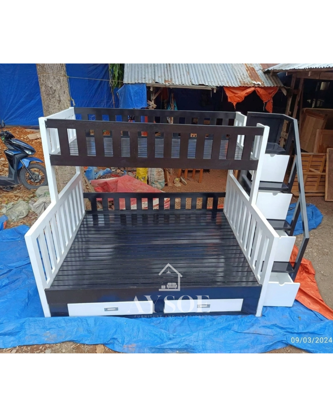 A black and white solid wood bunk bed with a single upper bunk, a wider lower bed, a staircase with four storage drawers, and two more drawers under the bed. Sturdy and space-saving for shared rooms.