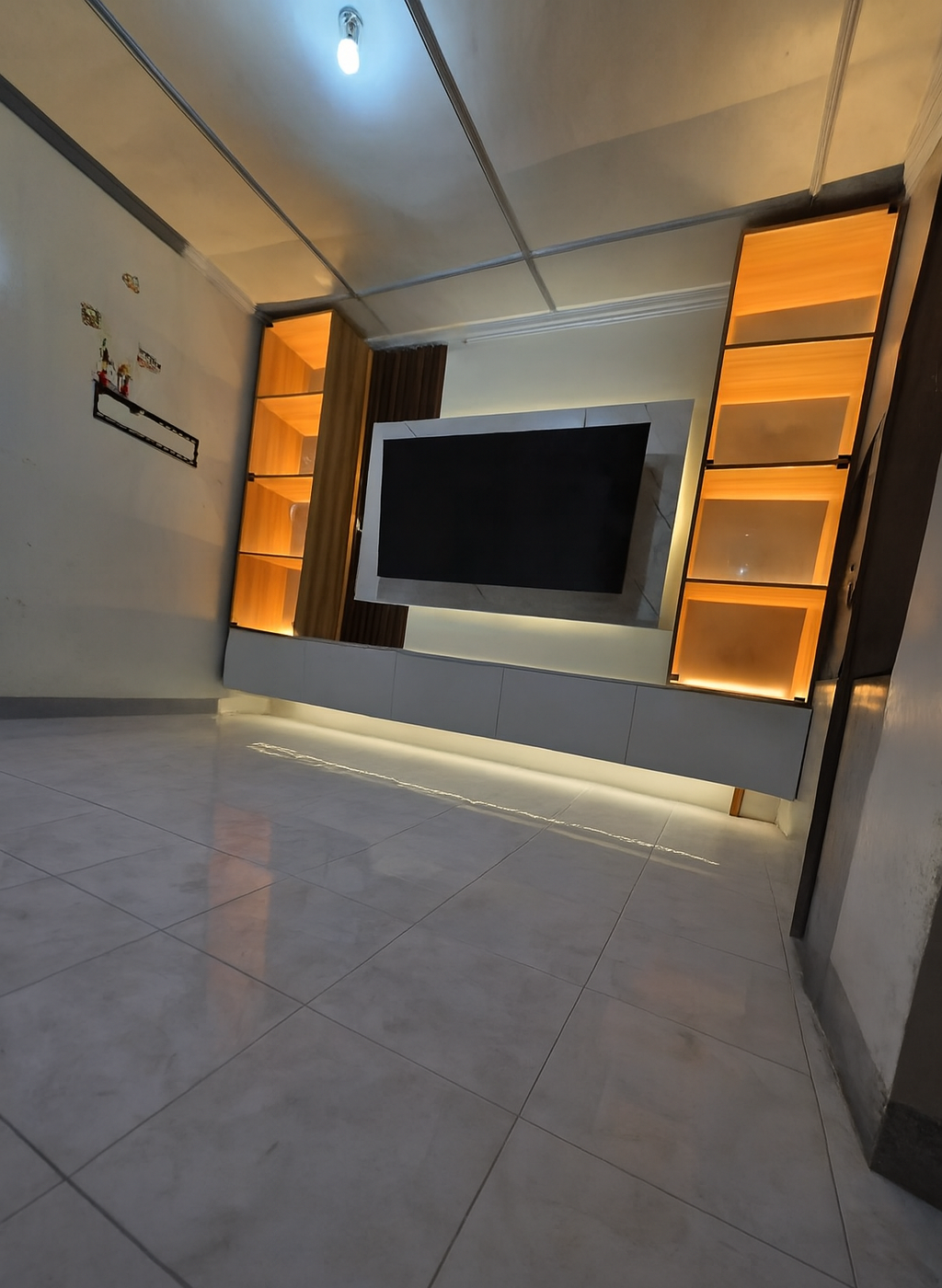 A built-in TV wall with a floating white storage cabinet, a marble-look TV backing panel, a fluted wood accent, and two tall glass-door display towers with warm LED lighting. Made to fit your wall.