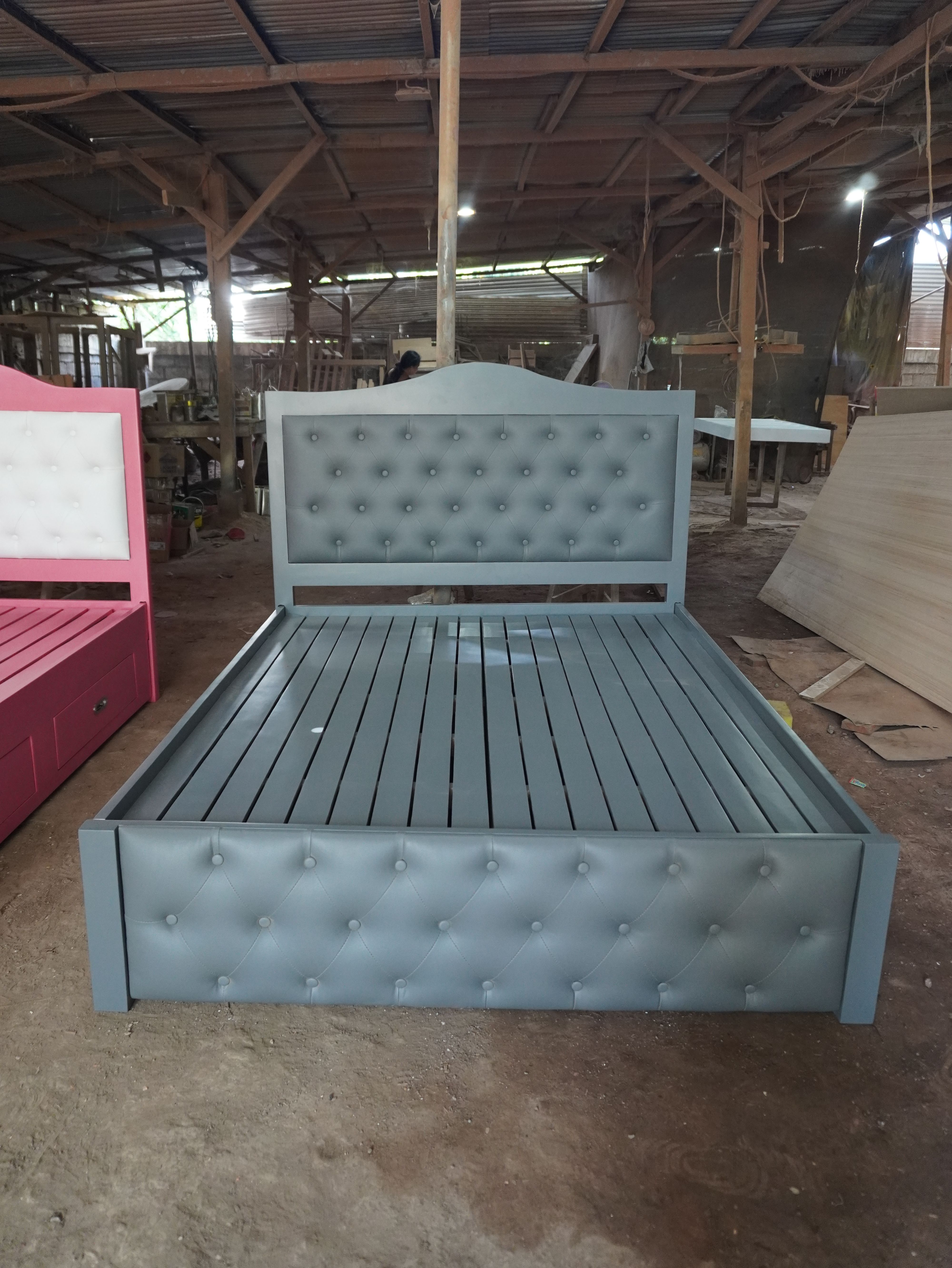 A classic storage bed in soft slate gray, with an arched wood-framed headboard, button-tufted leatherette panels on the headboard and footboard, and built-in side drawers with recessed metal pulls.
