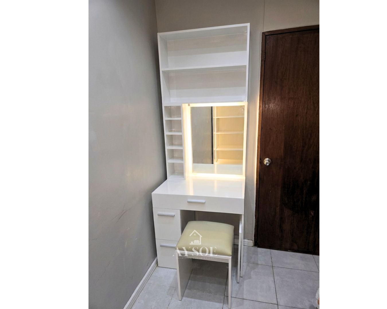 A compact white vanity dresser with an LED-lit mirror, three drawers, open shelves, and a cushioned stool. Perfect for makeup and grooming in small bedrooms.
