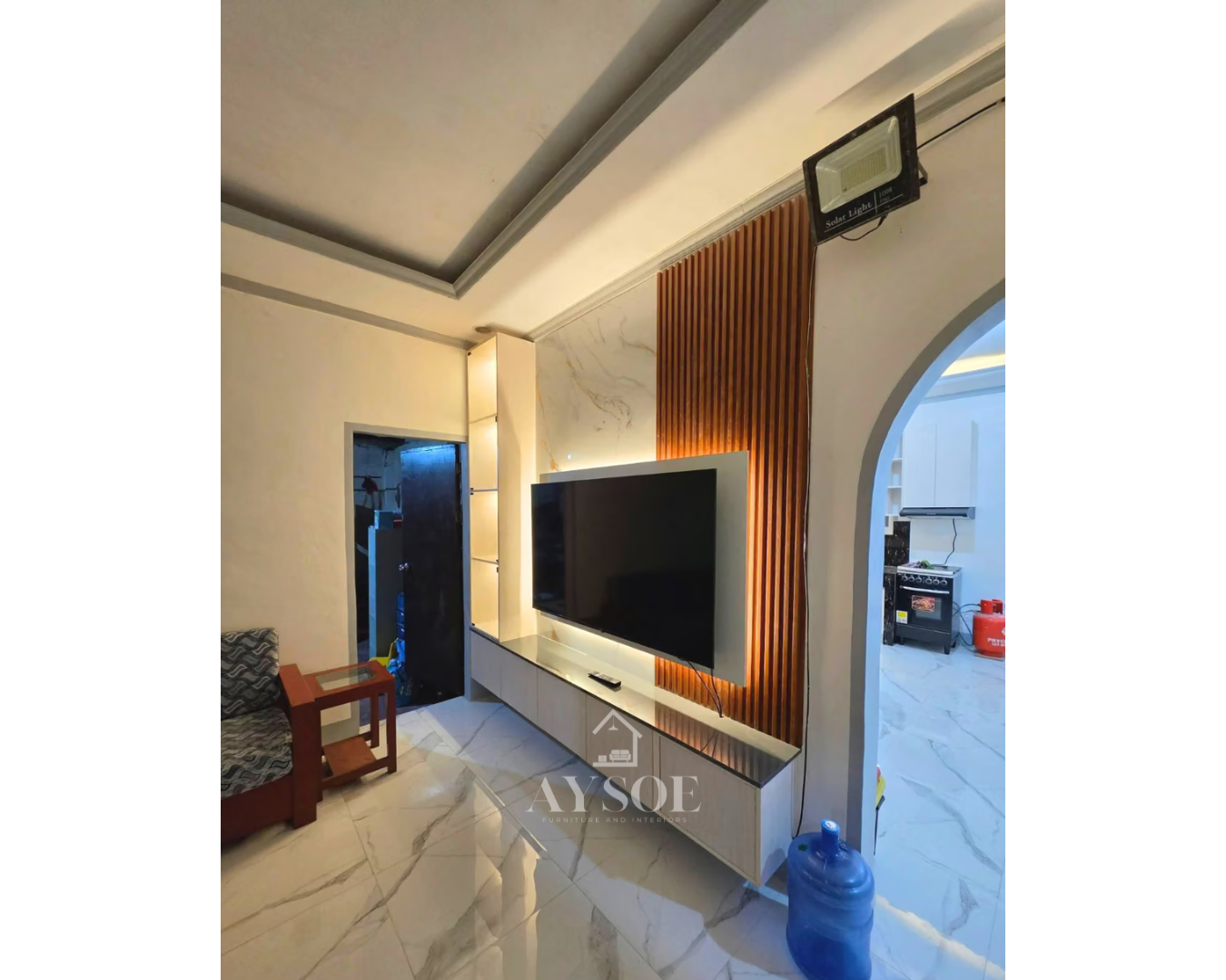 Floating TV wall unit with a marble-look backdrop, wood slat accent, and warm LED-lit display shelves.