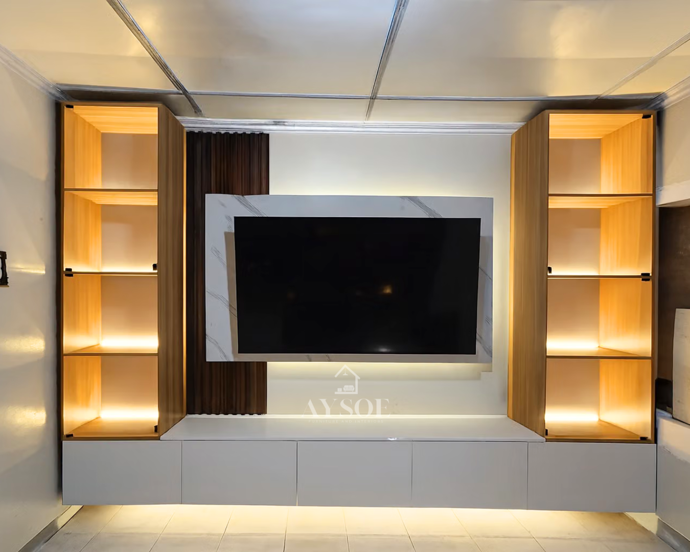 A built-in TV wall with a floating white storage cabinet, a marble-look TV backing panel, a fluted wood accent, and two tall glass-door display towers with warm LED lighting. Made to fit your wall.