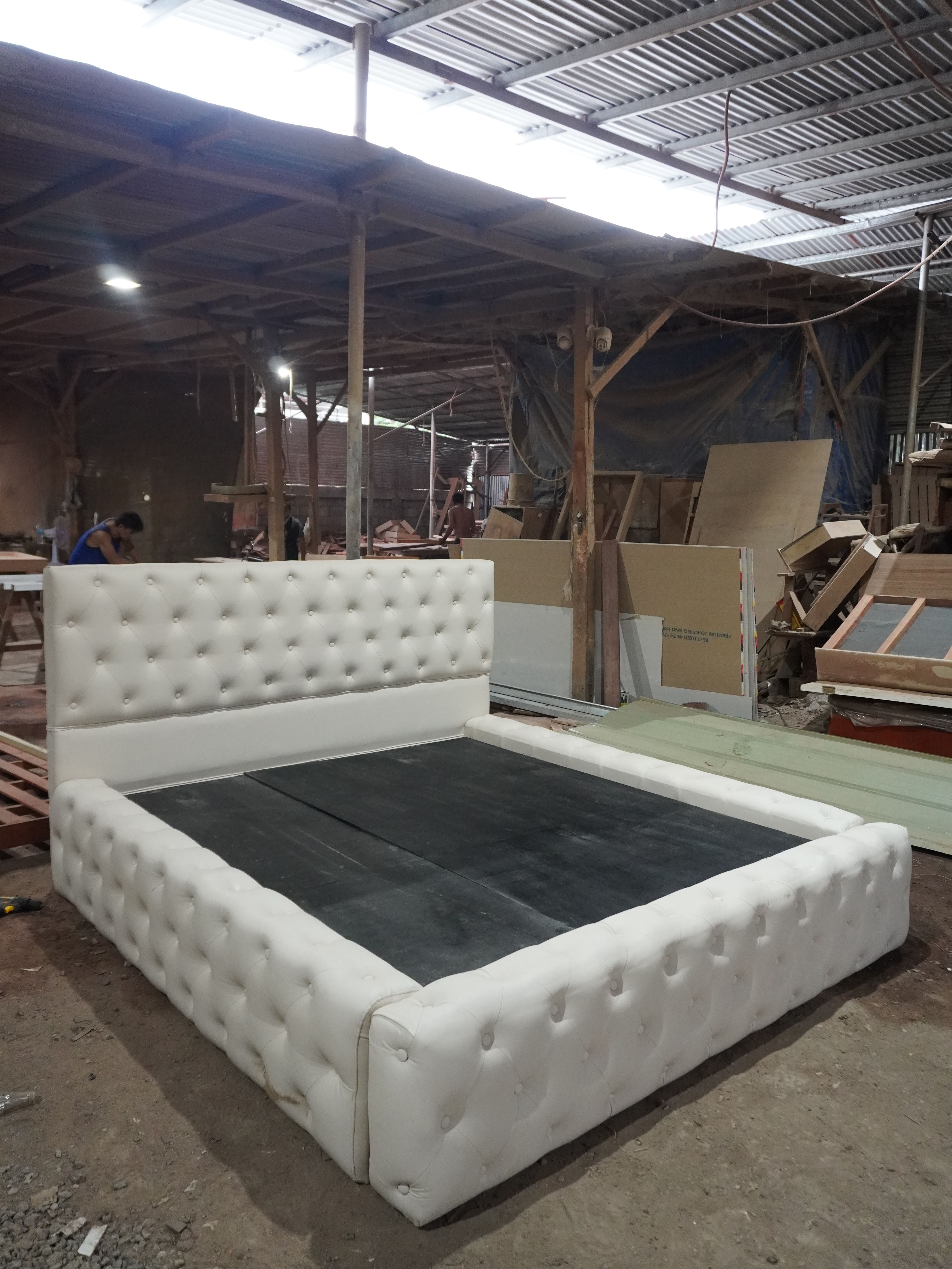 Sleep in luxury on this white button-tufted bed, with a tall padded headboard and a plush, wraparound footboard for a statement bedroom look