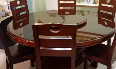 Chairs: Six matching slat-back chairs with uniquely designed backrests that have a circular cut-out at the top and horizontal slats below it.