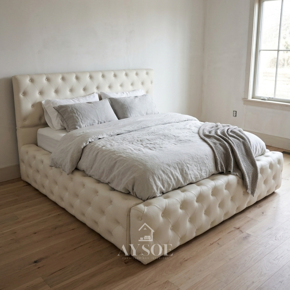 Sleep in luxury on this white button-tufted bed, with a tall, padded headboard and a plush, wraparound footboard for a statement bedroom look. Available in a range of sizes, in fabric or leather.