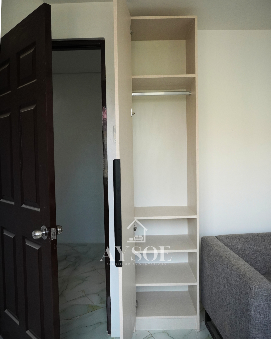 A custom bedroom set in a cream linen-texture finish, with a built-in study desk with two drawers and two wardrobes with hanging rods and shelves. Complete storage and a work spot for small rooms.