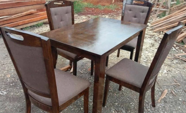 The chairs have high, solid backs and are upholstered with smooth, light brown or taupe fabric seat cushions.