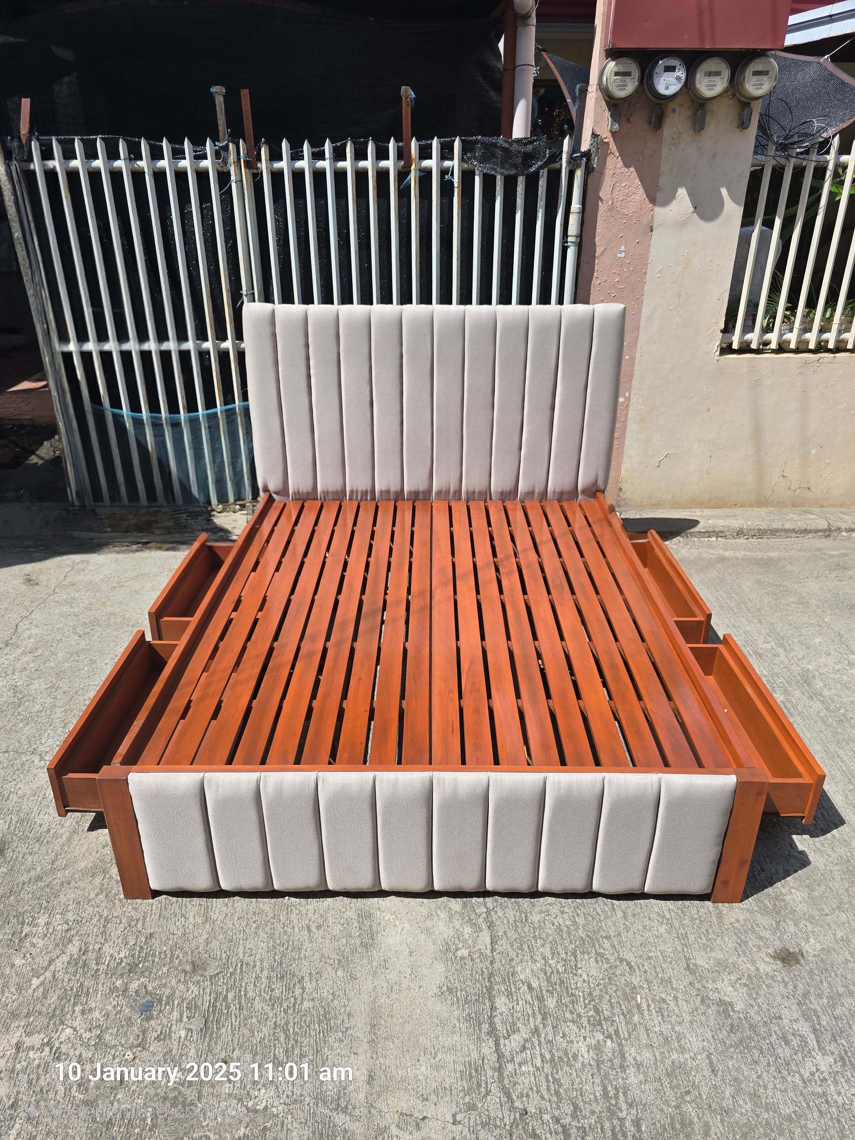 A two-tone bed that pairs a warm cherry wood frame with soft light gray channel-panel upholstery. Four built-in side drawers and a sturdy slatted base give you plenty of storage and firm mattress support.