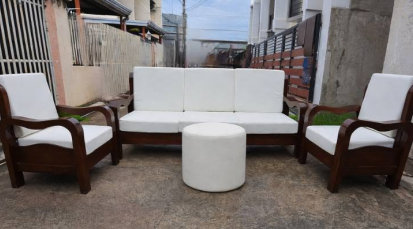 The Single Armchairs: Two matching single-seater armchairs with the same dark wood frames and white cushions flank the main sofa on either side.