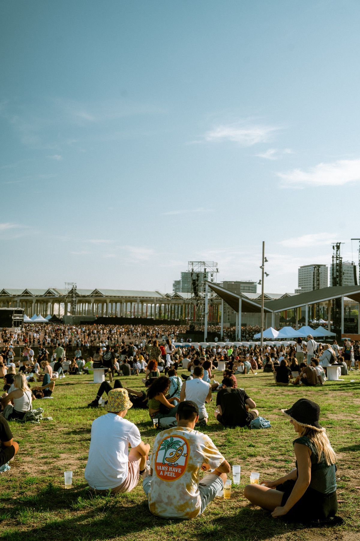 A large crowd enjoying an outdoor music festival in a city park