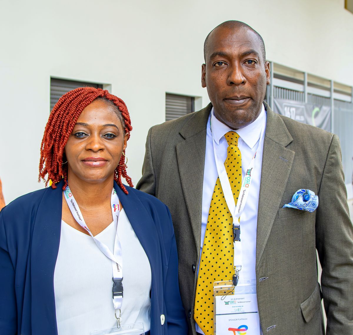 Two conference attendees wearing name badges and smiling together