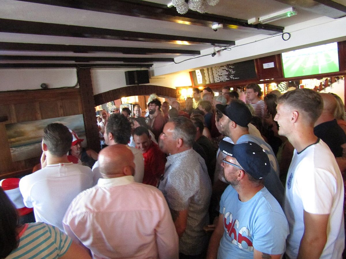 England supporters watching a football match beside the bar inside The Crown pub in Sheringham, Norfolk