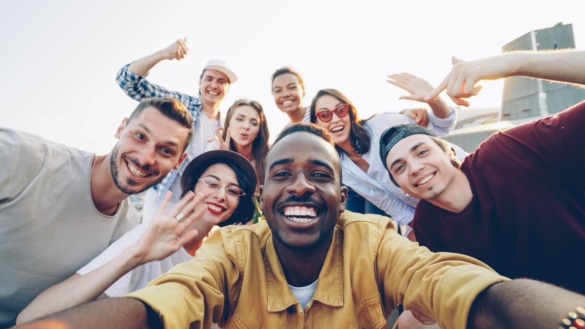 A diverse group of adult friends smiling together outdoors