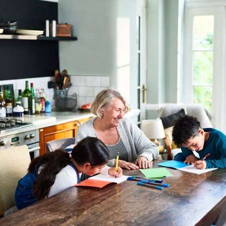Pensioner doing homework with her grandchildren