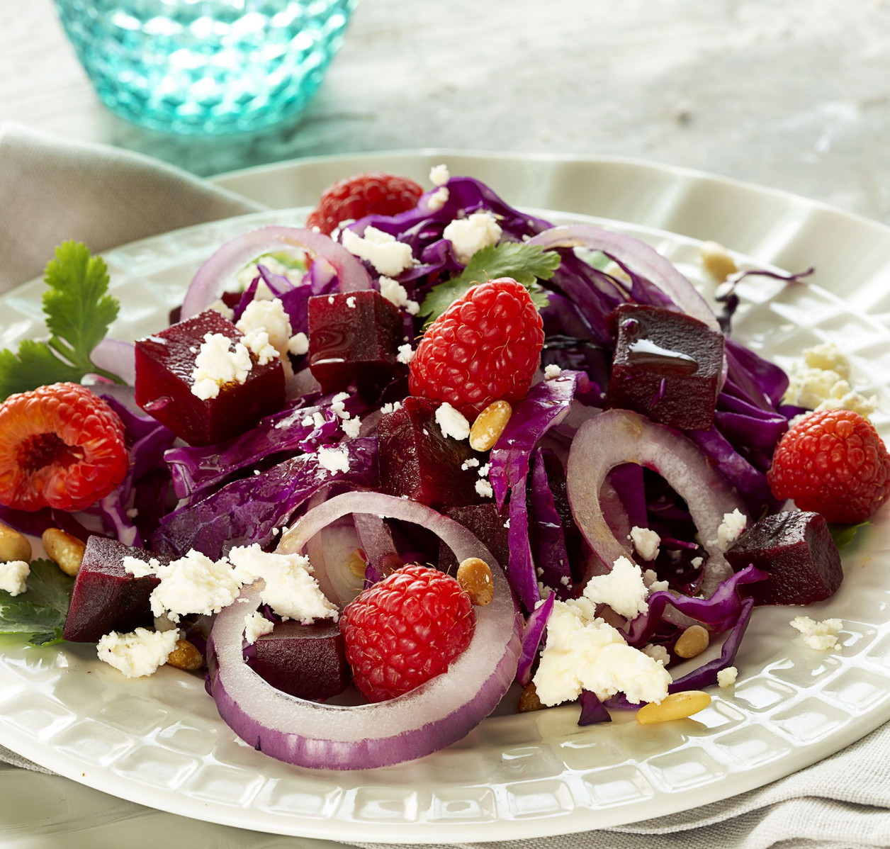 Ensalada de lombarda, remolacha, frambuesas, cebolla morada, queso y piñones