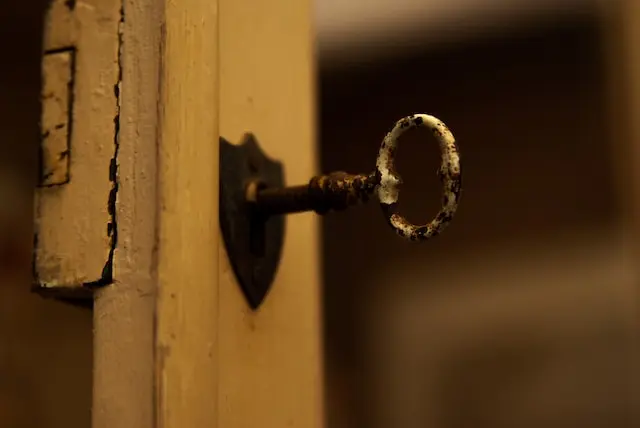 Llave antigua metida en la cerradura de una puerta de madera