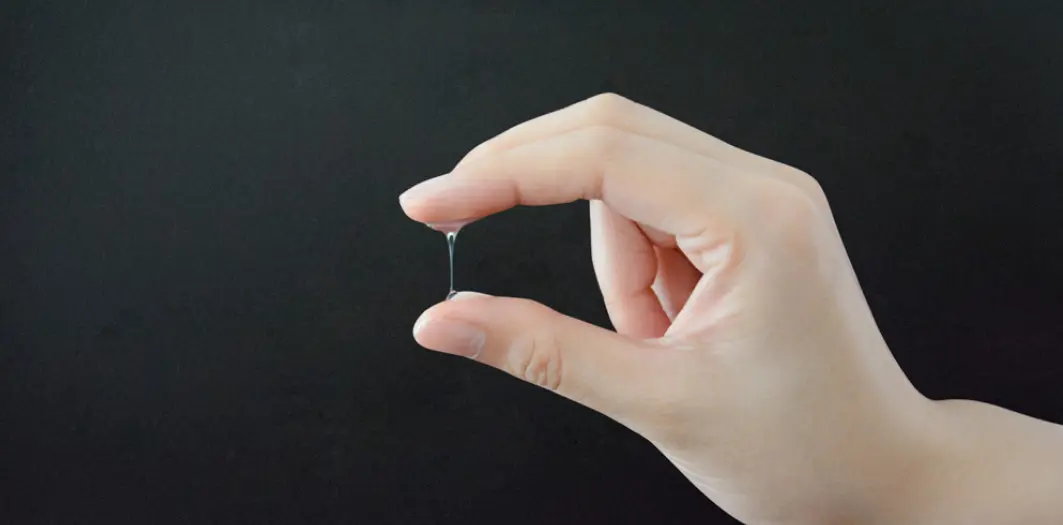Moco cervical acuoso y transparente entre el índice y el pulgar