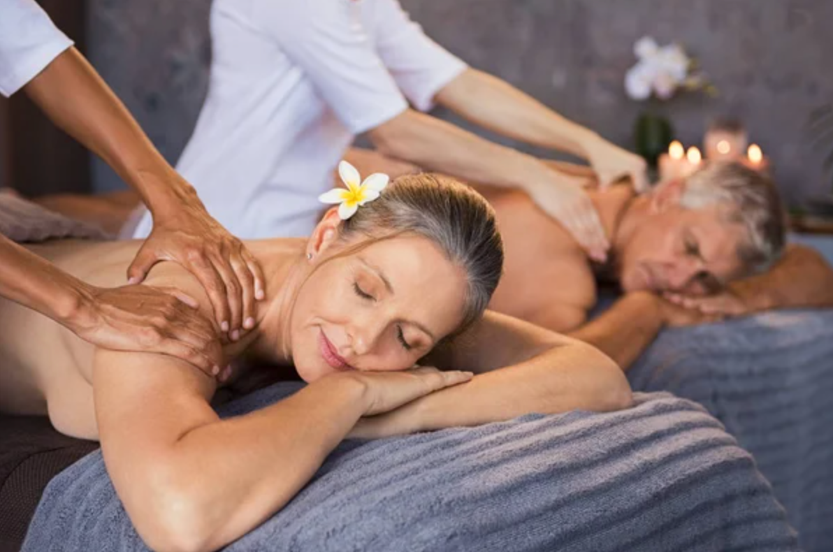 Pareja madura recibe un masaje de espalda en un spa con velas