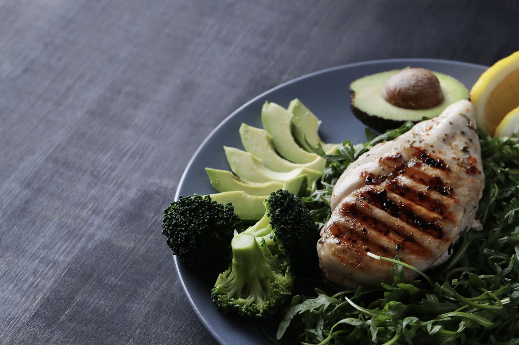 Plato con pechuga de pollo a la plancha, aguacate, brócoli y rúcula