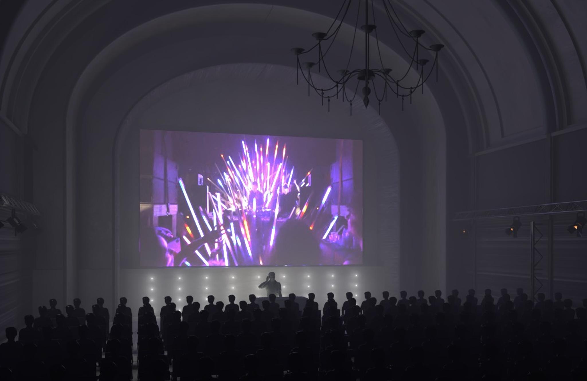 A digital mockup of a Symphony of Now screening in a white, arched hall.