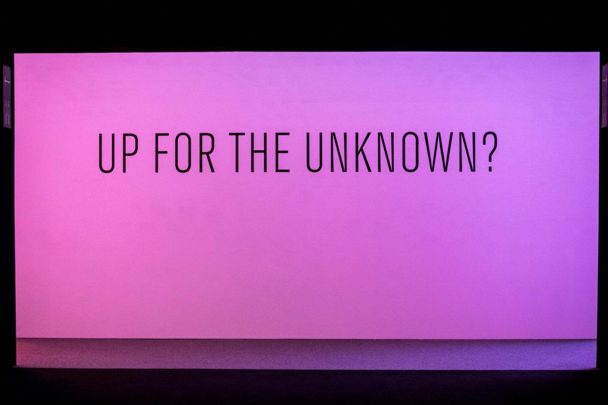 Black text on a pink background: "UP FOR THE UNKNOWN?"