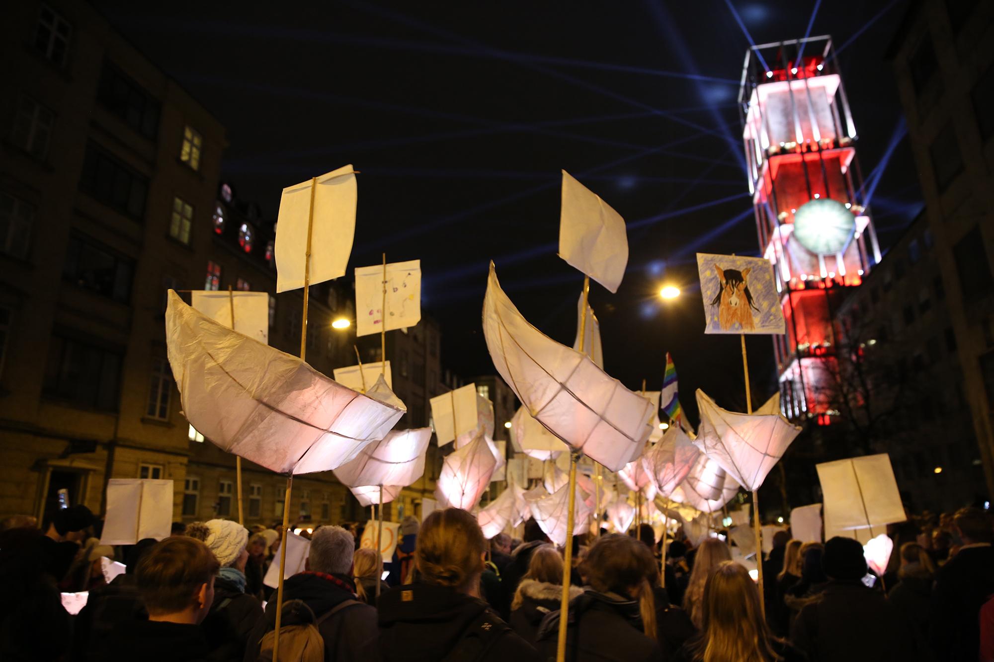 A parade of paper lanterns and children's drawings.
