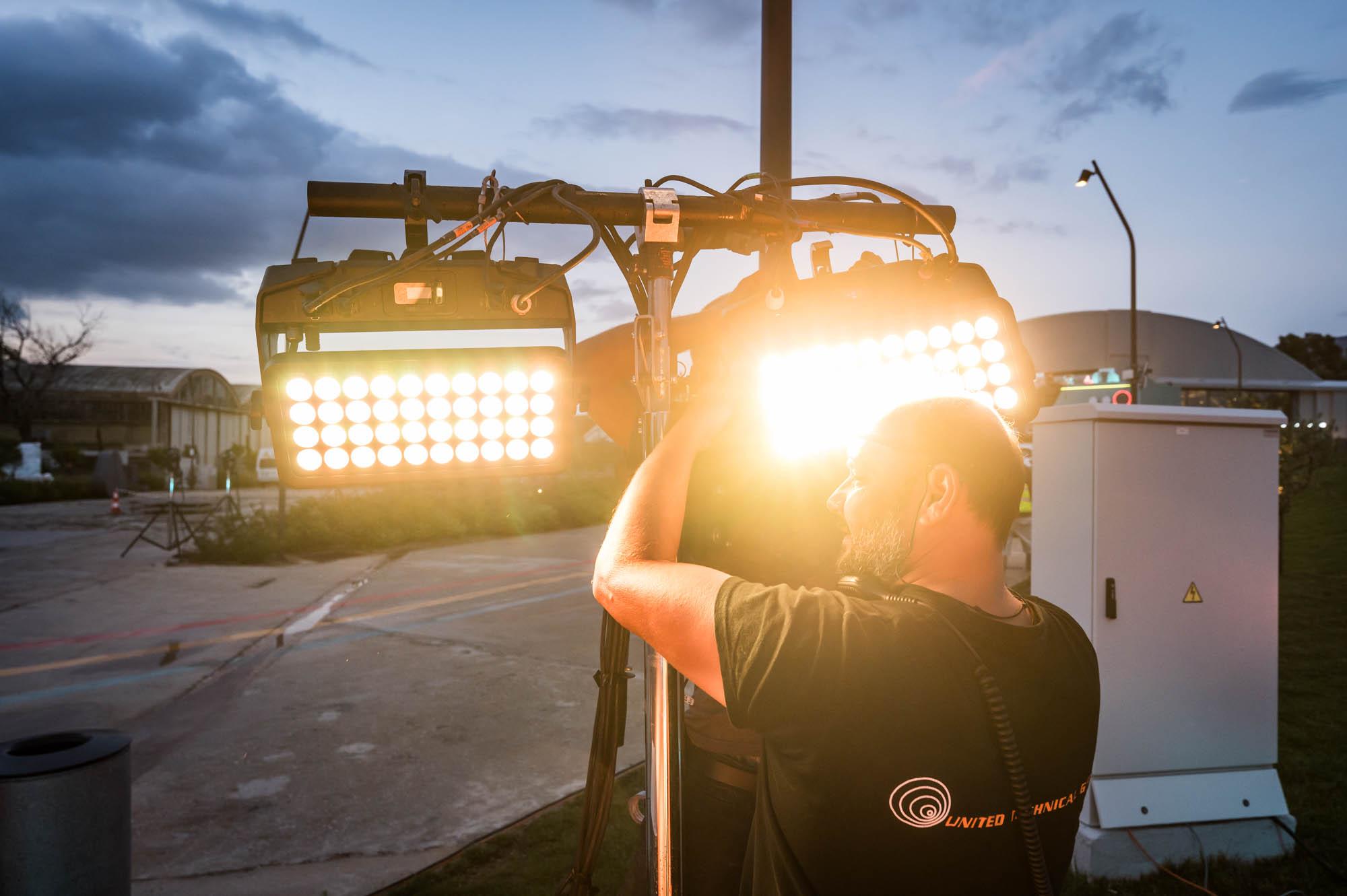 Man sets up floodlights at the Together X Event by Battle Royal Studios