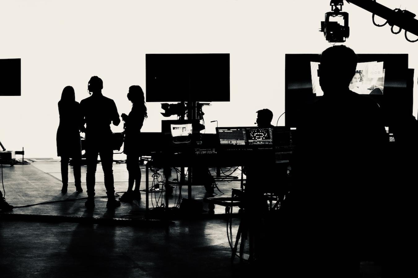 The silhouette of the crew on an indoor film set.