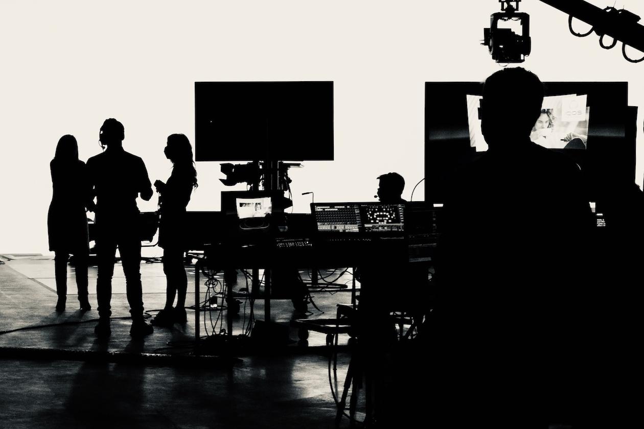 The silhouette of the crew on an indoor film set.