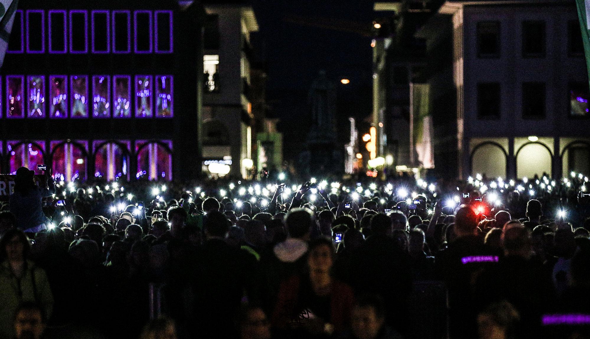 Participants shine their phone lights in the old city in Karlsruhe.