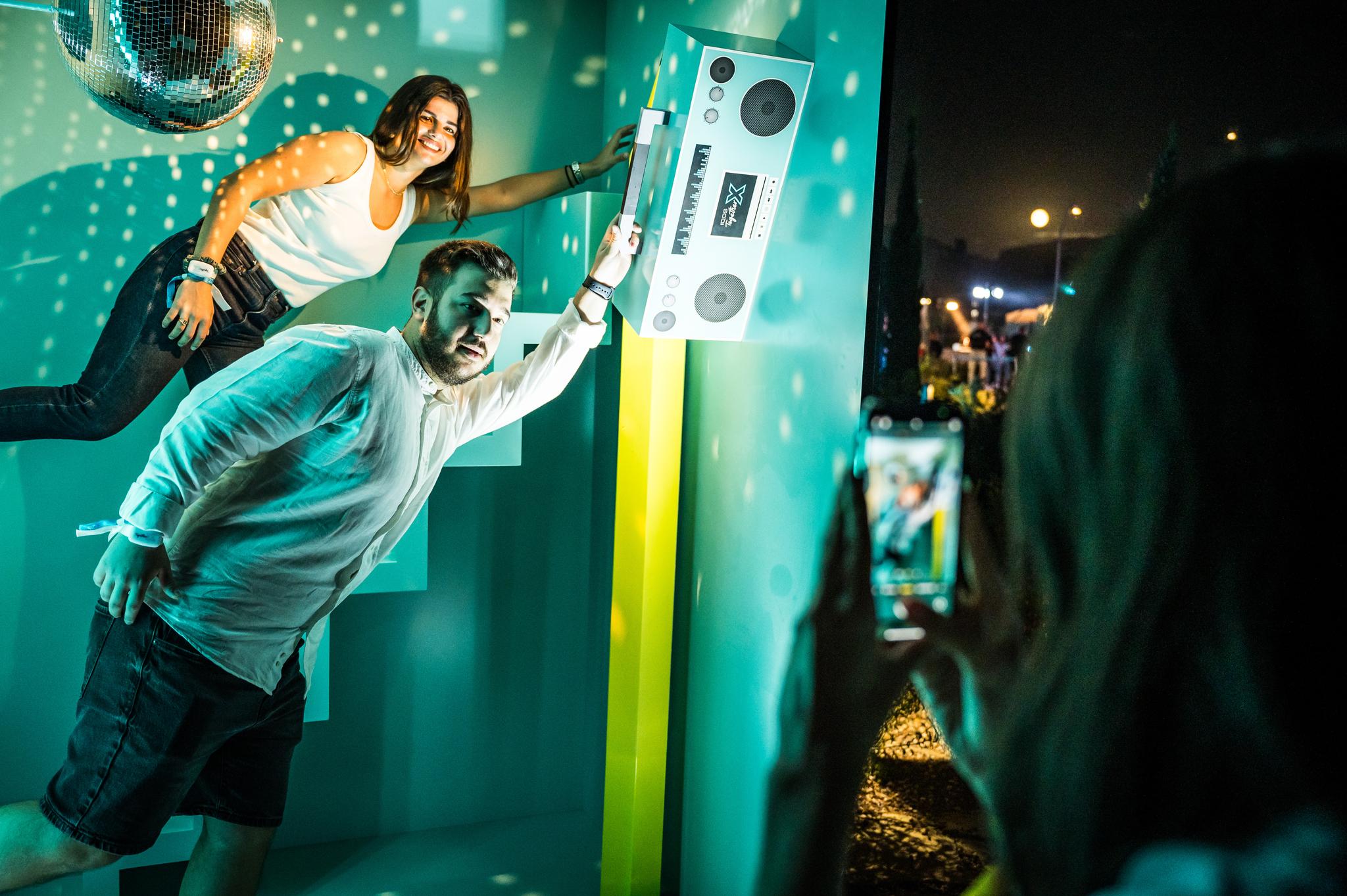 2 people experience an immersive experience in a photo box where it looks like they are flying at the Together X event in Athen by Battle Royal Studios